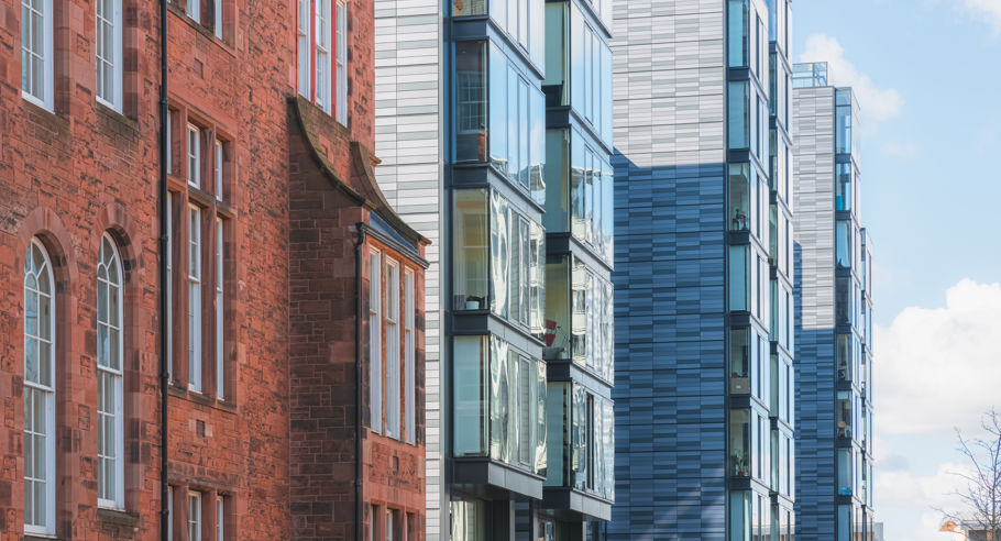 An older red brick apartment complex next to a modern build