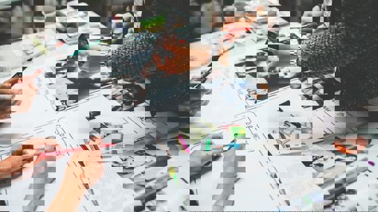 Image of the hands of people working on a magazine