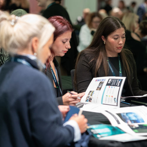People Sitting around a table reading a brochure