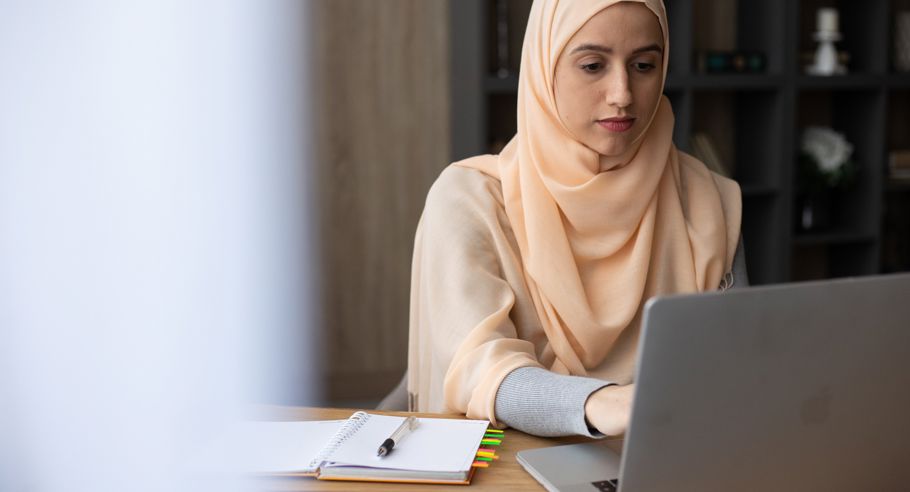 A woman sitting at a desk with a laptop